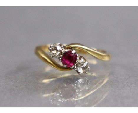 A gold cross-over design ring set round-cut ruby between two diamonds, hallmarks rubbed; size: F; 2.5gm. 