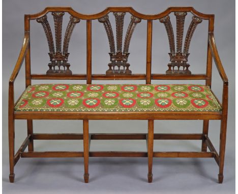 A Victorian mahogany small sofa with carved Prince of Wales feather splat-back supports, with padded seat, on square tapered 