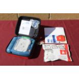 A Philips HeartStart defibrillator in hard carry case, with owners manual, and a smart pad cartridge