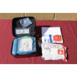 A Philips HeartStart defibrillator in hard carry case, with owners manual, and a smart pad cartridge