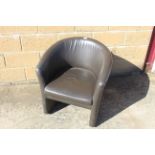 A leather effect tub shaped armchair SUBJECT TO VAT