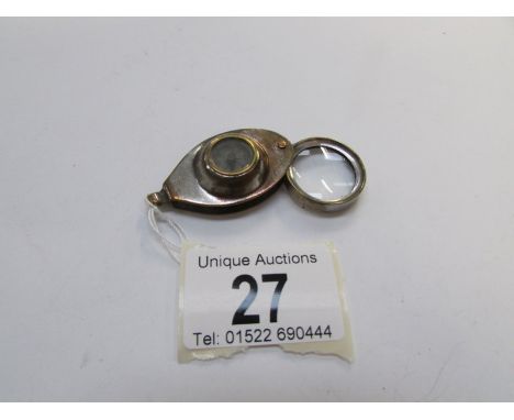 A small brass compass incorporating a magnifying glass