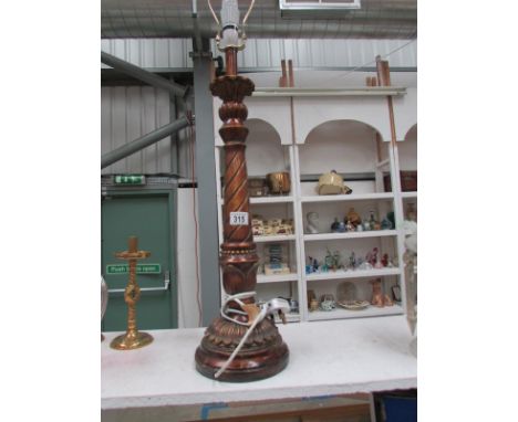 A tall carved wood table lamp