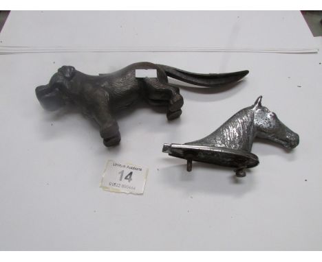A cast iron nutcracker in the form of a dog and a car mascot in the form of a horse head