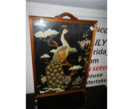 A Victorian oak fire screen with silk peacock