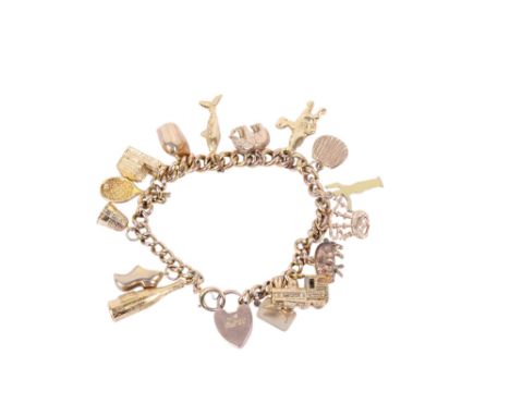 A 9ct gold charm bracelet with gold and yellow metal charms. The links marked 9ct, with 9ct hallmarked gold heart lock, charm