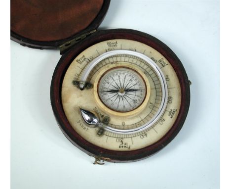 An early 20th century circular combination mercury thermometer and compass, mounted on ivorine, in a fitted black case 8cm (3