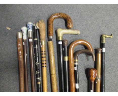 A collection of thirteen walking canes to include a clarinet cane, two drinker's canes with glass cups, two umbrella canes, t