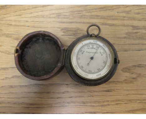 A circular pocket barometer, housed in a leather case  