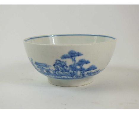 A Bow porcelain slop or waste bowl circa 1755-60, painted in early blue with a landscape scene of trees, rocks, shrubs and tw