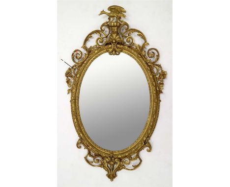 A large 19th century gilt plaster wall mirror in the Chinese Chippendale manner, of oval form, the plate set within a floral 