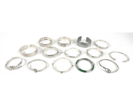 A collection of fourteen silver bangles, including a Chinese jade and silver hinged bangle, all stamped between 925 and 999, 