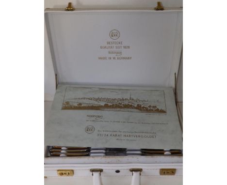 A white briefcase fitted with a 70 piece parcel-gilt stainless steel cutlery set by Bestecke, Solingen, 12 place settings.