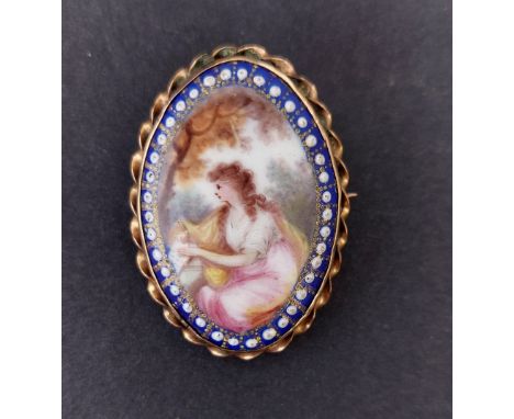 An antique enamel painted oval gold brooch, depicting a seated female in landscape, 1.5".