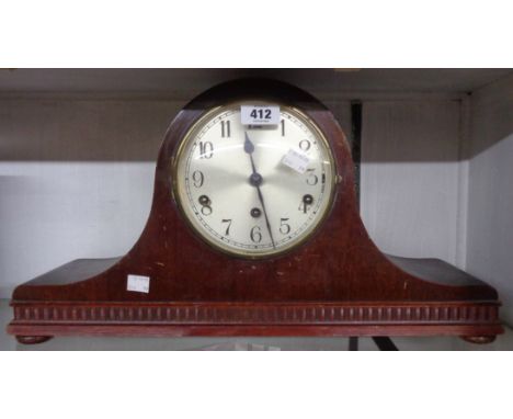 A 1920's stained mixed wood cased Napoleon hat mantle clock with German eight day chiming movement