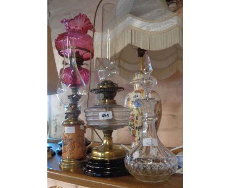 A Victorian table oil lamp with clear glass reservoir and original chimney - sold with another novelty lamp in the form of a 