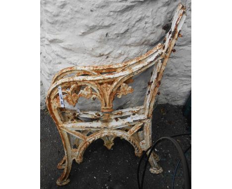A pair of old painted cast iron bench ends with vine leaf decoration