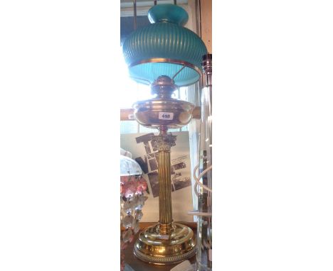 A brass table oil lamp with corinthian column, chimney, and reeded green glass shade