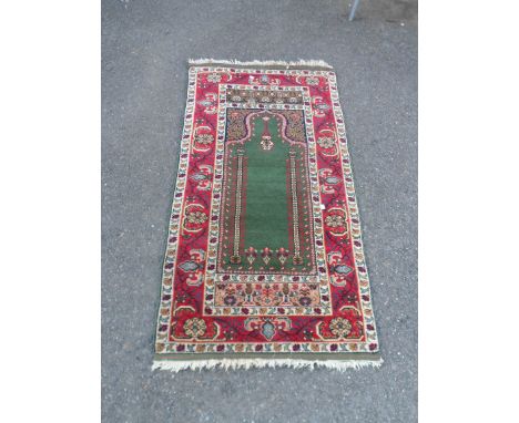 A Middle Eastern wool prayer mat featuring central mihrab and Mosque lamp within a floral border - 1.47m X 77cm