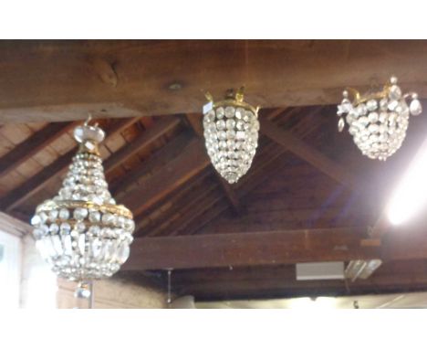 A brass two-tier drop light fitting with glass lustres - sold with two smaller similar