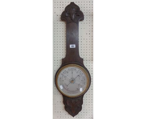 An early 20th Century carved oak framed aneroid barometer - no thermometer scale - dial glass a/f