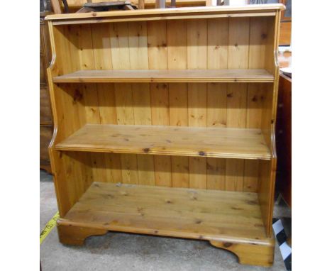 A pair of 96.5cm Ducal polished pine three shelf open waterfall bookcases with moulded decoration, set on bracket feet and ca
