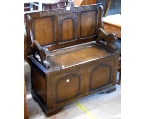 A 95cm 20th Century stained mixed wood monk's bench with flanking lion pattern supports and locker seat, set on bracket feet