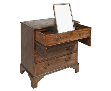 A George III mahogany commode table or dressing chest, the upper drawer divided into compartments and centred by an adjustabl