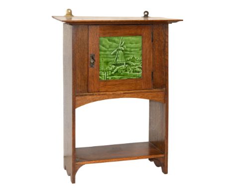 An oak wall hanging cupboard, early 20th c, the door enclosed with green glazed earthenware tile, 54 x 40cm  