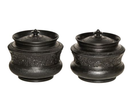 A pair of black basalt tobacco jars and covers, c.1820, attributed to Charles Bourne, sprigged with flowers between engine tu