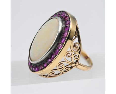 A large and impressive opal and ruby cluster ring set in unmarked yellow gold, size M