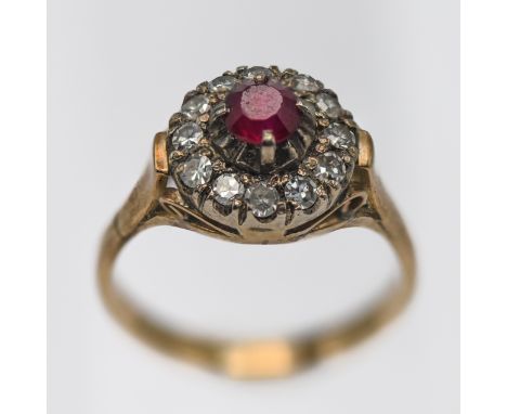 A ruby and diamond cluster ring, set in yellow gold, stamped 18k, size L/M.