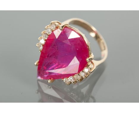 IMPRESSIVE RUBY AND DIAMOND DRESS RING
set with a large pear cut ruby of approximately 15 carats, flanked by five brilliant c