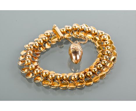 TWENTIETH CENTURY EIGHTEEN CARAT GOLD BRACELET
with circular and spherical links, the safety chain with an acorn motif drop, 