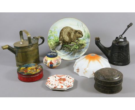 A brass watering can along with a metal unbreakable oil lamp marked C Wells & Co together with a Goebel plate, two old tins a