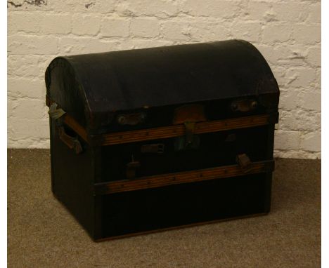 A canvas bound dome topped travel trunk with timber and metal mounts and having leather straps.