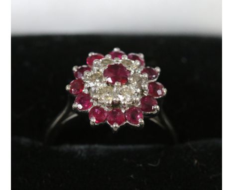 An 18ct white gold ruby and diamond cluster ring, size L.