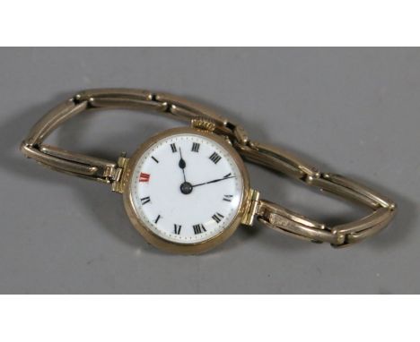 A ladies 9 carat gold cased manual wristwatch on expanding gold plated bracelet strap. With enamel dial and Roman numeral mar