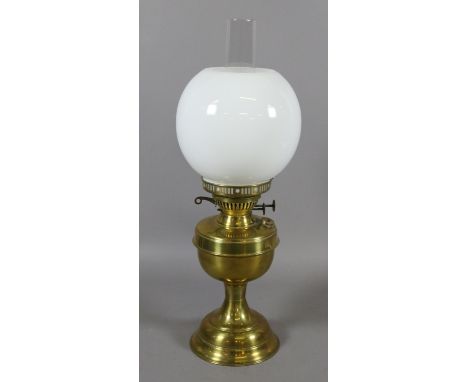 A brass based oil lamp with milchglas shade.