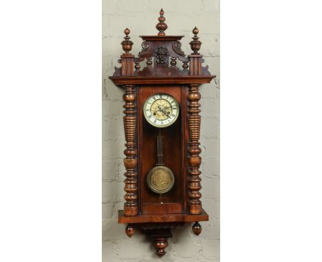 A late nineteenth century Vienna wall clock in walnut case. With gilt dial having enamel chapter ring and housing a twin trai