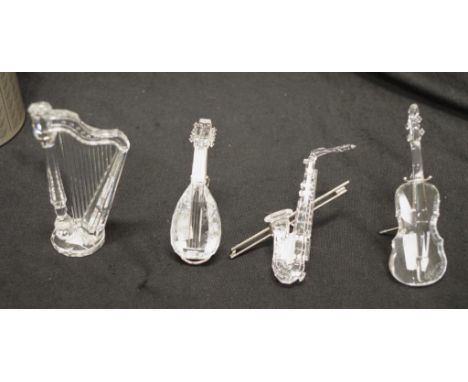 Four Swarovski crystal musical instruments all retired comprising #211728 Saxophone, #7477 Lute, #203056 Cello, and #7477 Har