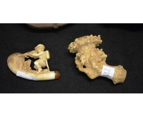 Two carved meerschaum pipe ends with hinged cases (worn), comprising of a man shooting a firearm (5cm wide) and a circle of a