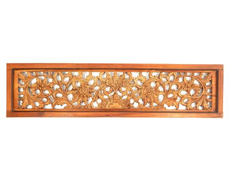 Indian hardwood panel, having carved and pierced scrolling foliate design within a frame 132 x 33 x 3cm