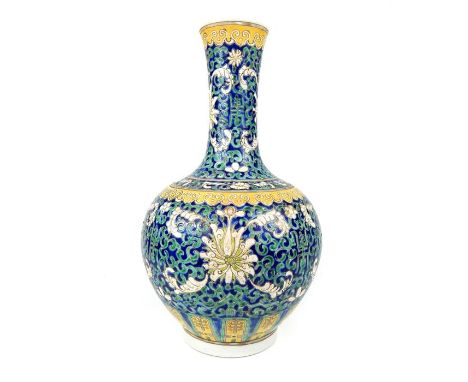 A  Chinese pottery bottle vase, decorated with scrolling lotus in white enamel on blue ground, the base bears the six charact