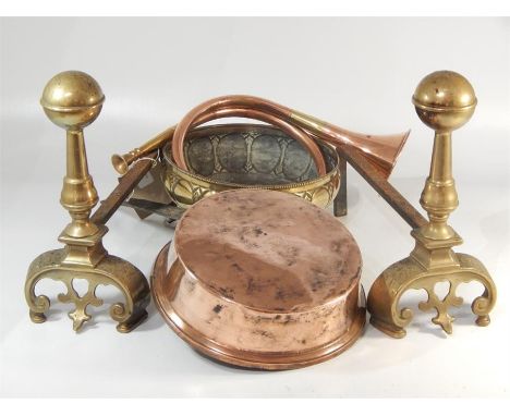A pair of brass fire dogs, together with a 19thC copper and iron pan, a hunting horn and an embossed brass bowl. (5)