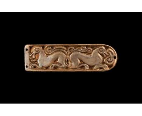 10th century AD. A tongue-shaped hollow strap end with gilt field, openwork motif of addorsed horses(?); attachment holes to 