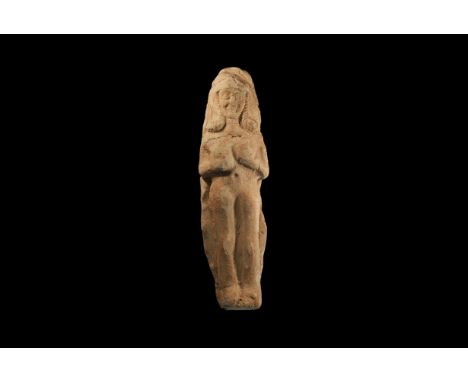 8th-6th century BC. A tongue-shaped ceramic plaque with a high-relief of a female with shoulder-long curled hair, wearing a p
