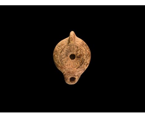 1st century AD. A terracotta oil lamp with rosette to the discus, short D-shaped nozzle, lug handle to the rear. Cf. Bémont, 
