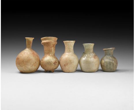 1st-3rd century AD. A group of glass vessels consisting of: a bottle with flaring rim, globular body, small trails to the sho