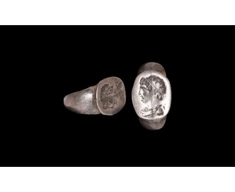 246-222 BC. A Hellenistic silver finger ring comprising a tapering D-section hoop, ellipsoid bezel with intaglio profile bust